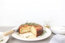 Lemon and thyme syrup cake with slice missing — Stock Photo