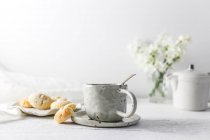 Чашка чая и миндального печенья за столом — стоковое фото