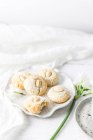 Plate of Almond Macaroons and a flower composition — Stock Photo