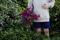 Junge hält einen Blumenstrauß in der Hand — Stockfoto