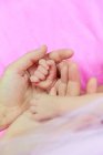 Woman's hands holding a baby girl's hands — Stock Photo