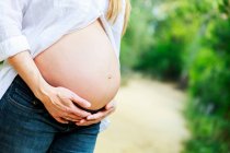 Pregnant woman holding her belly — Stock Photo