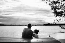 Padre e figlia seduti in riva al mare, Noosa Heads, Queensland, Australia — Foto stock