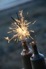 Closeup view of Lit sparklers em garrafas de vidro na praia — Fotografia de Stock