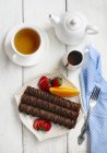 Chocolate crepes with tea over white table — Stock Photo
