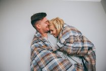 Homem e mulher abraçando em uma colcha — Fotografia de Stock