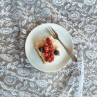 Vista dall'alto della torta con ribes rosso e mirtilli sul piatto — Foto stock