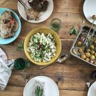 Вид крупним планом смажена картопля з цибулею, салатом та м'ясом на грилі — стокове фото