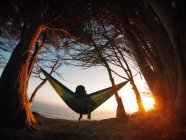 Boy sitting in a hammock looking at Pacific Ocean, California, America, USA — Stock Photo