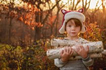 Щасливий хлопчик, що носить дрова на природі — стокове фото