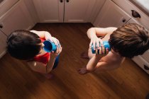 Мальчик и девочка стоят на кухне и пьют воду — стоковое фото