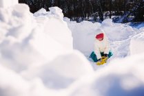 Menina jogando na neve no dia ensolarado de inverno — Fotografia de Stock