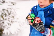 Boy holding Christmas decorations outdoors — Stock Photo