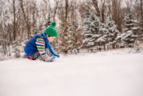 Garçon jouant dans la neige — Photo de stock