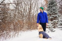 Homme caressant chien golden retriever dehors dans la neige — Photo de stock