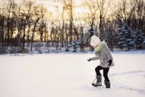 Дівчина йде снігом на заході сонця — стокове фото