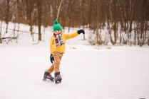 Мальчик катается на коньках по замерзшему озеру — стоковое фото