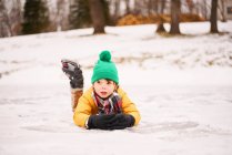 Niño patinaje sobre hielo y cayendo - foto de stock