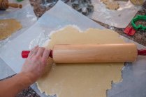 Женщина катит тесто для рождественского печенья — стоковое фото