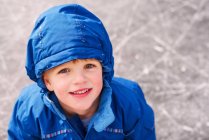 Retrato de menino sorridente em pé em uma pista de gelo — Fotografia de Stock
