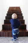 Menino de pé no fundo das escadas — Fotografia de Stock