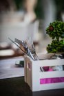 Knives and forks in wooden box on table in restaurant — Stock Photo