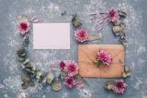 Vista de close-up do envelope em branco e cartão com flores — Fotografia de Stock