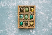 Vista superior de los huevos de Pascua en una caja de madera - foto de stock