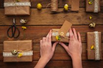 Enfants mains tenant cadeau de Pâques sur table en bois — Photo de stock