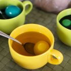 Tassen mit Eiern und Farbstoff für Ostern — Stockfoto