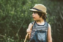 Ritratto ravvicinato di Boy che cammina attraverso il campo portando un bastone — Foto stock
