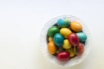 Top view of bowl of colored Easter eggs — Stock Photo