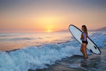 Woman walking into ocean with surfboard, Los Lances beach, Tarifa, Cadiz, Andalucia, Spain — Stock Photo