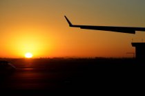 Silhouette of an airplane wing at sunset — Stock Photo