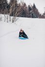 Junge rodelt in der Natur den Berg hinunter — Stockfoto