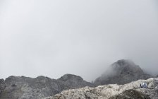 Rocky mountains in fog clouds — Stock Photo