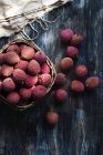 Basket with lychee fruits over wooden table — Stock Photo