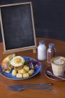 Breakfast, Coffee and Empty Chalkboard over table — Stock Photo