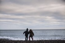 Rear view of Boy and girl playing on the beach, Ireland — Stock Photo