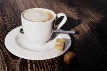 Closeup view of Cappuccino coffee with sugar cubes — Stock Photo