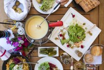 Käsefondue und Gemüse über Holztisch — Stockfoto