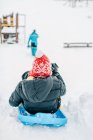 Мальчик катается на санках с горы зимой — стоковое фото