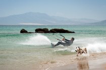 Mann Kitesurfen und Hund laufen am Strand, Los Lances, Tarifa, Cadiz, Andalusien, Spanien — Stockfoto