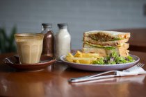 Café da manhã clube sanduíche e café sobre mesa de madeira — Fotografia de Stock