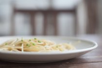 Vista close-up de placa de espaguete com cebolinha, foco seletivo — Fotografia de Stock