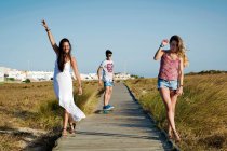 Tre persone che camminano lungo il lungomare, Tarifa, Cadice, Andalusia, Spagna — Foto stock