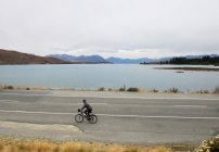 Homem pedalando ao longo da estrada costeira, Nova Zelândia — Fotografia de Stock