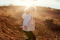 Дівчина біжить у полі на заході сонця — стокове фото