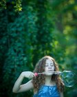 Дівчина дме гігантські мильні бульбашки — стокове фото