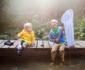 Два хлопчики сидять на дерев'яній дрібній риболовлі — стокове фото